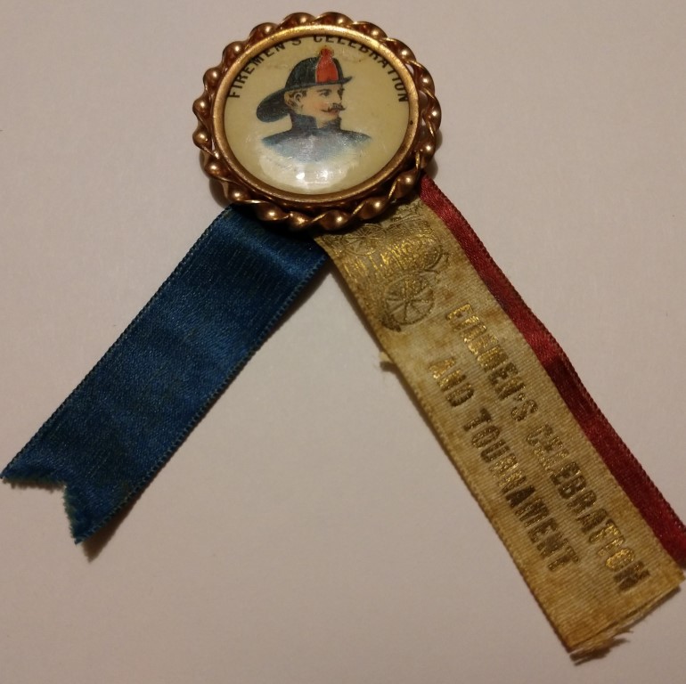 Neat old pin depicting a fireman with red, white a