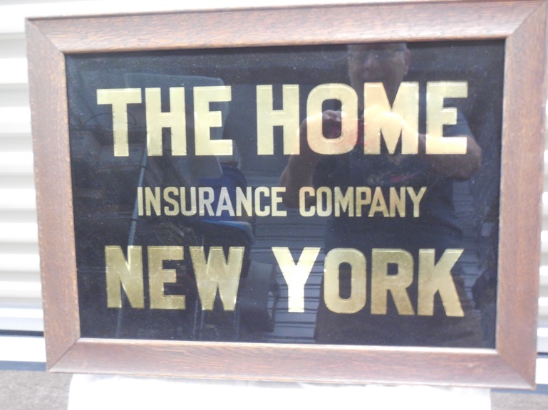Reverse glass Home Insurance Sign. 23 1/8" X 17 1/8". Back is stamped Demzi & Phillips.